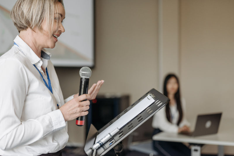 Sprecherin mit Mikrofon während eines Seminars